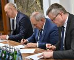 Podpisanie porozumienia dot. solarnej mapy Poznania; trzy osoby przy stole podpisują dokumenty